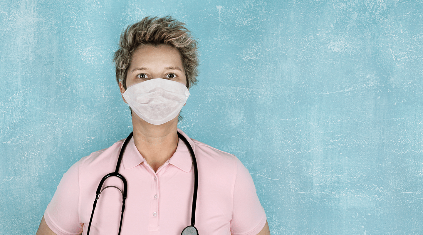 A nurse wearing a mask, against a blue background