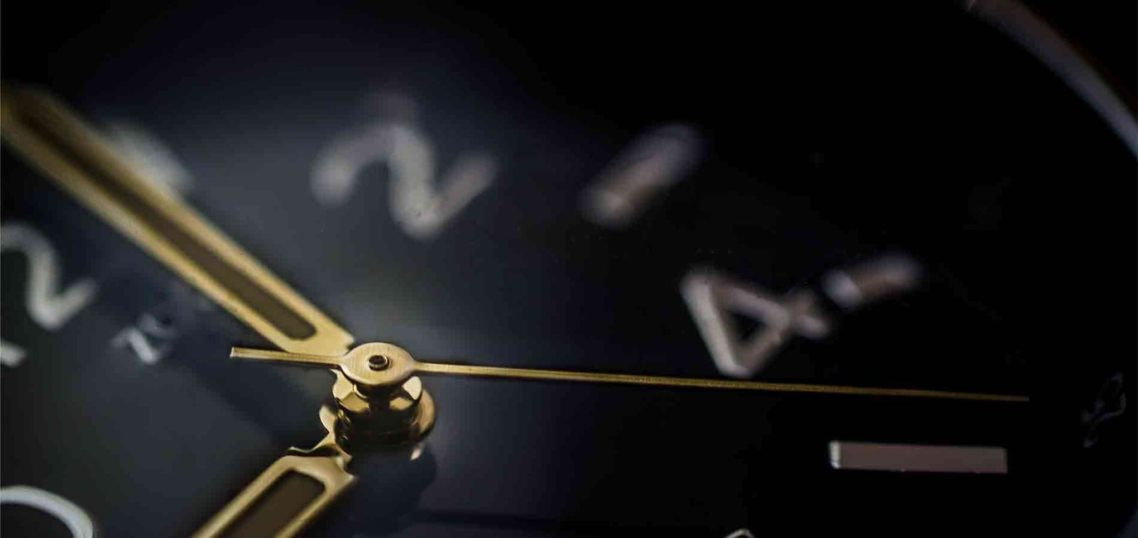 Close-up of a black clock with brass hands